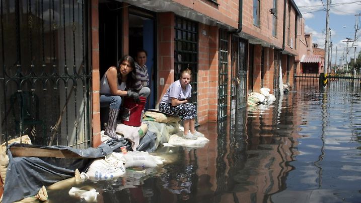 ACHTUNG: SPERRFRIST  23. März 1200 - ARCHIV - Frauen warten vor ihren teilweise unter Wasser stehenden Häusern am 09.12.2011 in Bogota (Kolumbien) auf Hilfe. In Kolumbien hatte das Wetterphämonen La Nina für Überschwemmungen gesorgt. Die Erderwärmung setzt sich nach Erkenntnissen der Weltorganisation für Meteorologie (WMO) weiter fort. So sei 2011 das wärmste Jahr mit einem kühlenden sogenannten La Niña-Effekt gewesen, seit 1850 die regelmäßige Aufzeichnung von Wetterdaten begann, erklärte die WMO am Freitag (23.03.2012) in Genf aus Anlass des Welttages der Meteorologie. Foto: MAURICIO DUENAS dpa (zu dpa "Klimawandel jetzt und heute - 2011 wärmstes Jahr mit La Nina" vom 23.03.2012  +++(c) dpa - Bildfunk+++