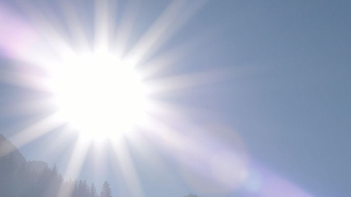 Die Sonne strahlt am 26.01.2017 in Garmisch-Partenkirchen (Bayern) über die Bäume, rechts ist der Waxenstein zu sehen. Foto: Angelika Warmuth/dpa +++(c) dpa - Bildfunk+++