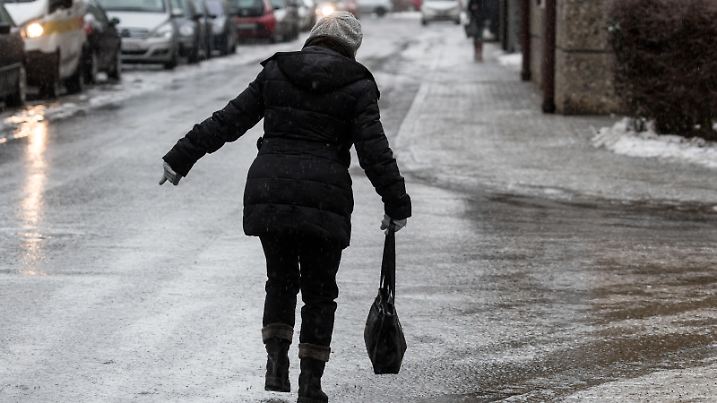 Eine Frau geht am 31.01.2017 in Straubing (Bayern) vorsichtig auf einer vereisten Straße. Der Deutsche Wetterdienst (DWD) warnt vor Glatteis in vielen bayerischen Landkreisen. Vor allem in der Oberpfalz, in Niederbayern und im bayerischen Wald müssen sich die Menschen auf glatte Straßen und Gehwege einstellen. Foto: Armin Weigel/dpa | Verwendung weltweit