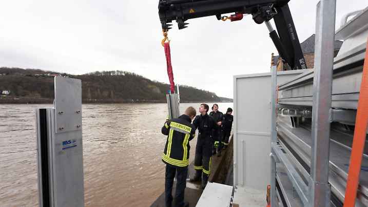 04.02.2020, Rheinland-Pfalz, Koblenz: Feuerwehrleute bauen am Rheinufer des Stadtteils Neuendorf eine mobile Hochwasserschutzmauer auf. Ihre erfolgreiche Bewährungsprobe hatte die in den vergangenen Jahren fertiggestellte mobile Mauer beim Hochwasser im Januar 2018. Foto: Thomas Frey/dpa +++ dpa-Bildfunk +++