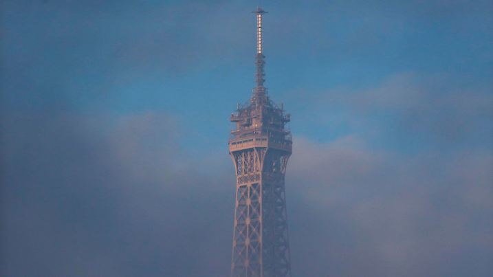 ARCHIV - 27.11.2015, Frankreich, Paris: Die Spitze vom Eiffelturm ragt aus tiefhängenden Wolken. (zu 130 Jahre Eiffelturm) Foto: Ian Langsdon/EPA/dpa +++ dpa-Bildfunk +++