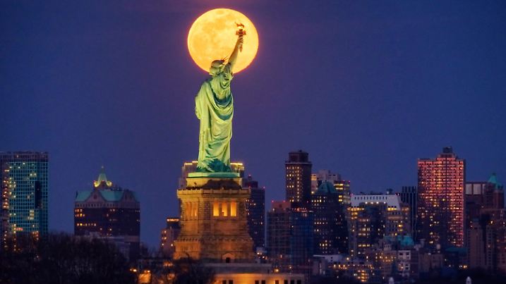 The rising full moon crosses behind the Statue of Liberty, Monday evening, March 9, 2020, in New York City. (AP Photo/J. David Ake)