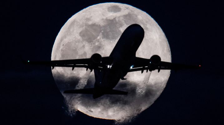 dpatopbilder - 09.03.2020, Hessen, Frankfurt/Main: Eine Passagiermaschine startet auf dem Flughafen Frankfurt vor dem tief am Himmel stehenden «Supermond». Die Luftfahrtbranche gehört zu den vom Corona-Virus am stärksten betroffenen Wirtschaftsbereichen. Foto: Boris Roessler/dpa +++ dpa-Bildfunk +++