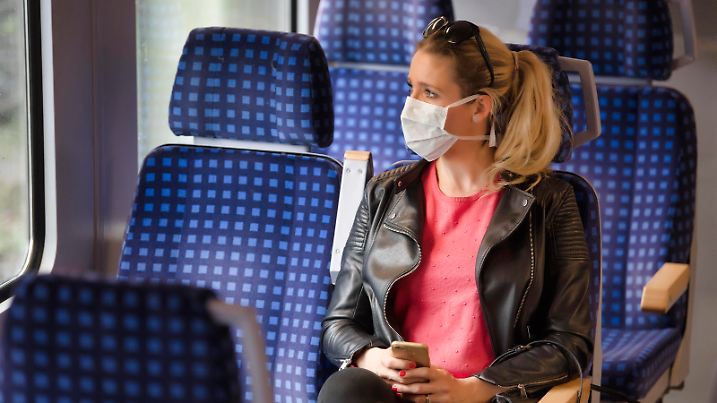 Frau mit Mundschutzmaske, sitzt in Zug, am Handy, Corona-Krise, Stuttgart, Baden-Württemberg, Deutschland Coronavirus *** Woman with a face mask, sitting in Zug, on a mobile phone, corona crisis, Stuttgart, Baden Württemberg, Germany Coronavirus