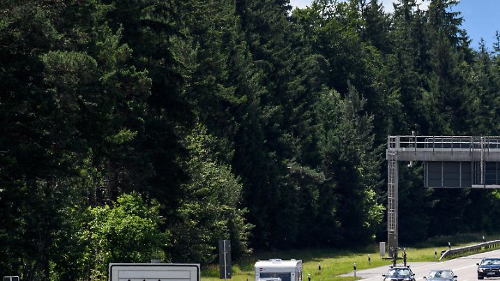 Dichter Verkehr schiebt sich am 01.07.2017 über die Autobahn 8 in Fahrtrichtung Salzburg und Brenner-Autobahn im Hofoldinger Forst bei Sauerlach (Bayern), während über der Straße auf einer digitalen Anzeige vor Stau gewarnt wird. Auf Bayerns Autobahnen staut sich der Verkehr an diesem Tag, da am Wochenende die Sommerferien in drei deutschen Bundesländern begonnen haben. Im Hintergrund sind die Alpen zu sehen. (zu dpa "Ferienbeginn in mehreren Bundesländern sorgt für Staus in Bayern" vom 01.07.2017) Foto: Matthias Balk/dpa +++(c) dpa - Bildfunk+++