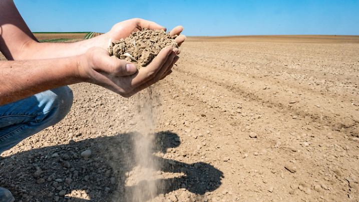 09.04.2020, Bayern, Kleinpinning: Ein Landwirt überprüft die trockene Erde auf seinem Feld. Foto: Armin Weigel/dpa +++ dpa-Bildfunk +++