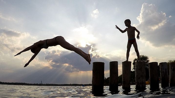 ARCHIV - 31.07.2018, Sachsen, Markkleeberg: Eine junge Frau springt von einer Buhne in den Markkleeberger See. Sonnenschein pur, Schweiß und Hitze: Von dem wochenlangen Hochsommer dieses Jahres haben nicht alle touristischen Angebote gleichermaßen profitiert. (zu dpa «Heißer Sommer: Touristen suchen kühle Angebote» vom 11.08.2018) Foto: Jan Woitas/ZB/dpa +++ dpa-Bildfunk +++