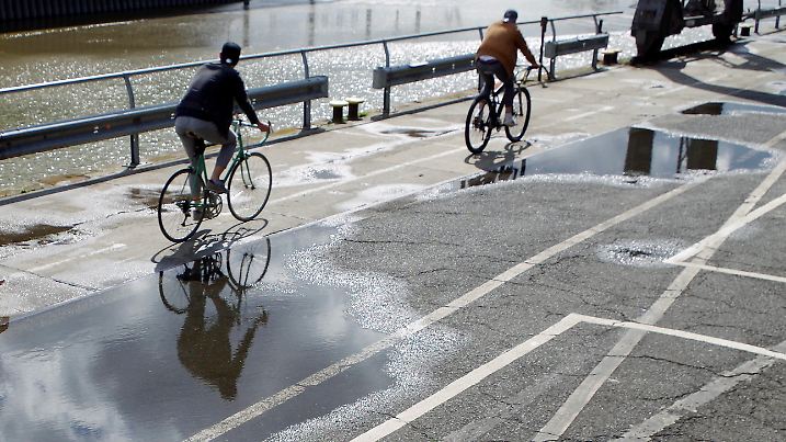  Feature: Wechselhaftes Wetter in Hamburg im Juli 2020. Ein Radfahrer spiegelt sich in einer Pfütze. *** Feature Changeable weather in Hamburg in July 2020 A cyclist is reflected in a puddle