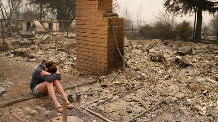 11.09.2020, USA, Talent: Desiree Pierce sitzt weinend in den Trümmern ihres Hauses, das bei den verheerenden Waldbränden in den USA durch das sogenannte Almeda-Feuer zerstört wurde. Im US-Bundesstaat Oregon sollen zuletzt mehr als 40 Brände gelodert haben, Tausende Feuerwehrleute waren demnach im Einsatz. Wegen des Almeda-Feuers nahe der Stadt Ashland mussten nach Behördenangaben mehr als 15.000 Anwohner ihre Häuser verlassen. Foto: John Locher/AP/dpa +++ dpa-Bildfunk +++