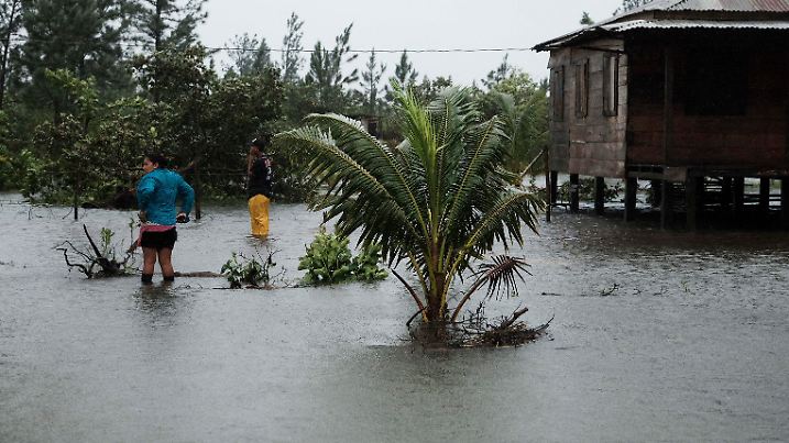 03.11.2020, Nicaragua, Wawa: Anwohner stehen vor einem von Überschwemmungen umgebenen Haus. Mit großer Wucht ist Hurrikan «Eta» auf die Ostküste von Nicaragua getroffen. Der gefährliche Wirbelsturm entwurzelte Bäume, deckte Dächer ab und ließ Flüsse über die Ufer treten. Foto: Carlos Herrera/AP/dpa +++ dpa-Bildfunk +++