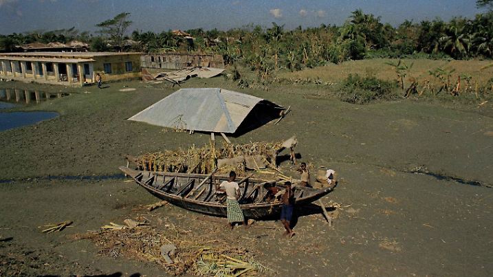 Two small boats are shown on the ground next to a rooftop that was blown away in the Bhola cyclone and tidal wave in East Pakistan, Nov. 18, 1970. (AP Photo/Harry Koundakjian) |