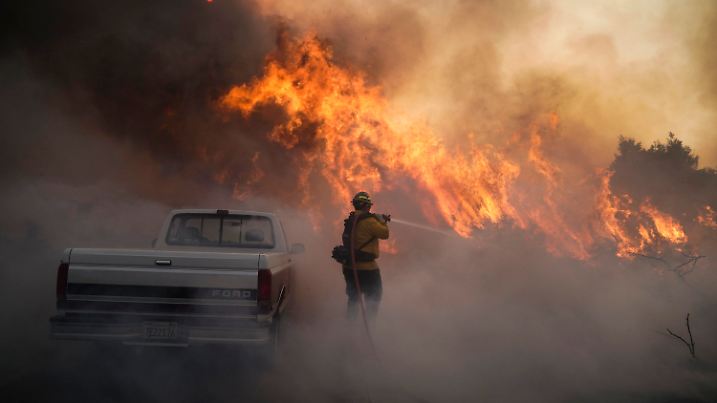 ARCHIV - 26.10.2020, USA, Irvine: Ein Feuerwehrmann ist beim Silverado Fire im Einsatz. Vier von fünf Naturkatastrophen sind nach einer Studie des Roten Kreuzes in den vergangenen zehn Jahren auf extremes Wetter und die Folgen der Klimakrise zurückgegangen. Dazu gehören Unwetter, Überschwemmungen und Hitzewellen. (zu dpa: "Rotes Kreuz: Mehr Katastrophen durch Klimawandel und Extremwetter") Foto: Jae C. Hong/AP/dpa +++ dpa-Bildfunk +++