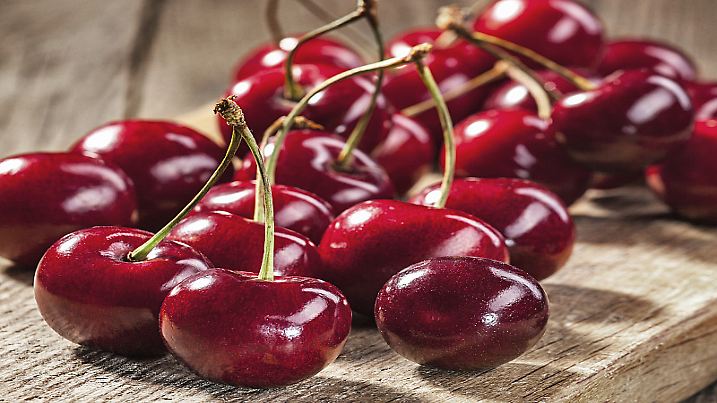 Ripe red cherries on old boards.