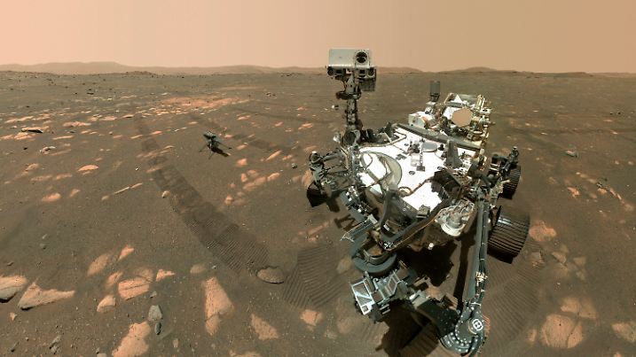 This Tuesday, April 6, 2021 image made available by NASA shows the Perseverance Mars rover, foreground, and the Ingenuity helicopter about 13 feet (3.9 meters) behind. This composite image was made by the WASTON camera on the rover's robotic arm on the 46th Martian day, or sol, of the mission. (NASA/JPL-Caltech/MSSS via AP)
