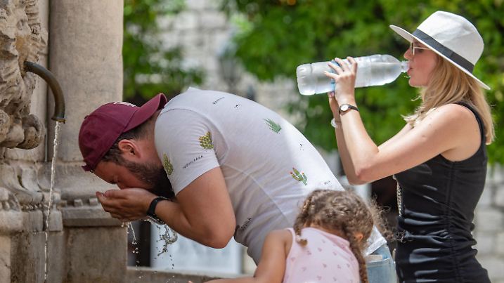 Heat wave in Croatia A man cools off as woman drink cold water at Onofrio fountain during a heat wave in Dubrovnik, Croatia on June 21, 2021. GrgoxJelavic/PIXSELL