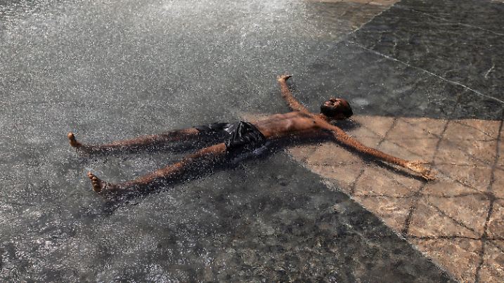 30.06.2021, Kanada, Edmonton: Kais Bothe entspannt und kühlt sich in einem Pool des Rathauses ab. Die anhaltende Hitzewelle im Westen Kanadas hat für neue Höchsttemperaturen gesorgt und zu mehreren Todesfällen beigetragen. Foto: Jason Franson/The Canadian Press/AP/dpa +++ dpa-Bildfunk +++