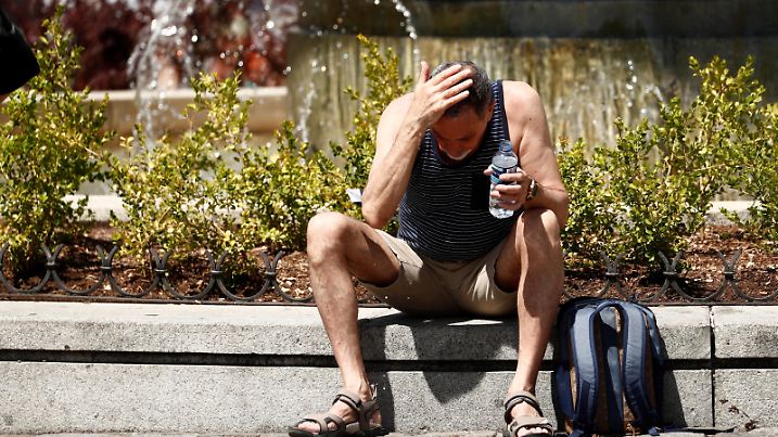 A man sitting next to a fountain pours water on his head to cool off, as heatwave hits the country, in Madrid, Spain, July 10, 2021. REUTERS/Javier Barbancho