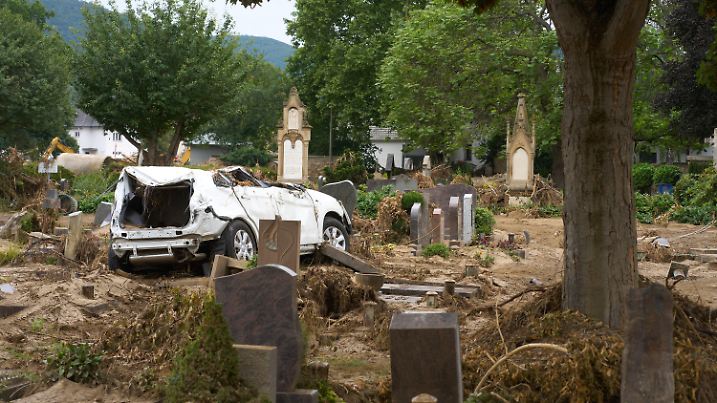 27.07.2021, Rheinland-Pfalz, Ahrweiler: Ein Auto, das bei der Hochwasserkatastrophe auf den Friedhof von Hannover Ahrweiler geschwemmt worden ist, steht auf einem Grabfeld. Der Friedhof ist total verwüstet. Foto: Thomas Frey/dpa +++ dpa-Bildfunk +++