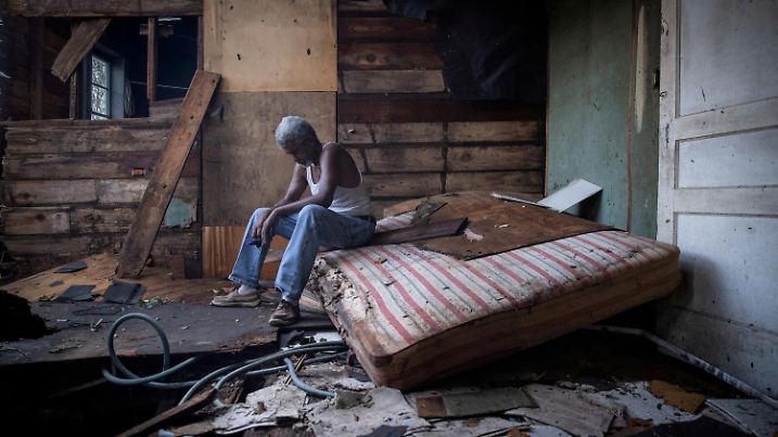 FILE PHOTO: Theophilus Charles, 70, sits inside his house which was heavily damaged by Hurricane Ida in Houma, Louisiana, U.S., August 30, 2021. REUTERS/Adrees Latif/File Photo
