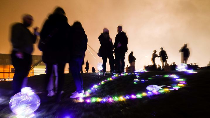 01.01.2022, Hamburg: Zahlreiche Menschen feiern den Jahreswechsel im Park Fiction auf Sankt Pauli an der Elbe über dem Hafen. Foto: Christian Charisius/dpa +++ dpa-Bildfunk +++