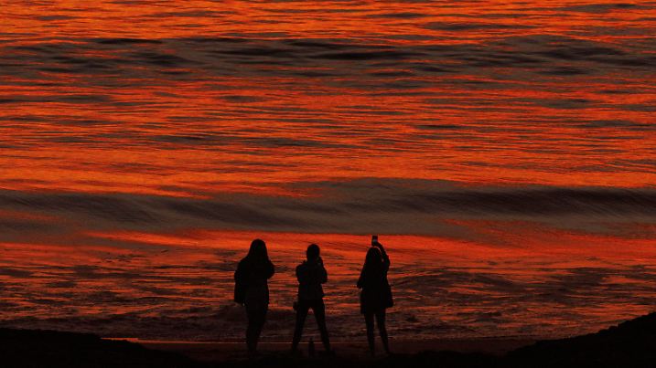 November 12, 2021, Los Angeles, California, U.S: People stand on the shoreline during a fall heatwave in Playa Del Rey. (Credit Image: © Jonathan Alcorn/ZUMA Press Wire