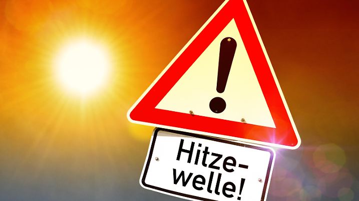 Brennende Sonne und Schild mit Aufschrift Hitzewelle, Symbolfoto KlimaerwÃ rmung und Hitzewelle