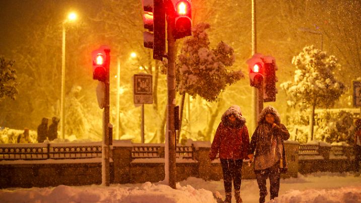 Pedestrians walk during snow fall in Istanbul, Turkey, on Monday, Jan. 24, 2022. A severe snowstorm disrupted road and air traffic Monday in the Greek capital of Athens and in neighboring Turkey's largest city of Istanbul, while snow blanketed most of Turkey and Greece, including several Aegean islands. (AP Photo/Emrah Gurel)
