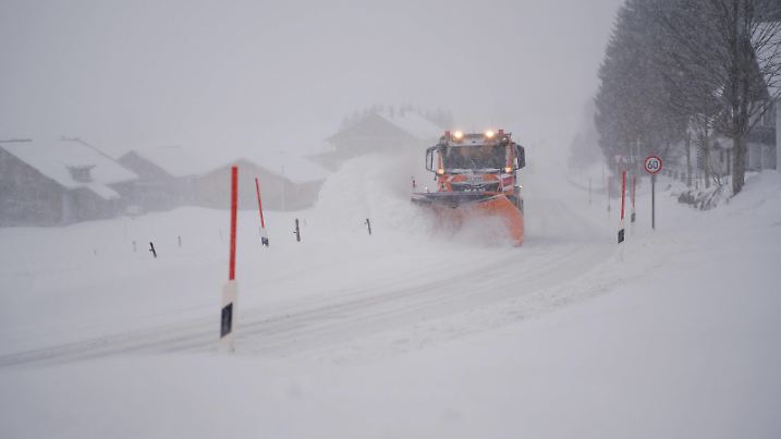 Ein Räumfahrzeug fährt über eine schneebedeckte Straße im Allgäu. / A clearing vehicle drives through a snow covered street in the Allgäu region of Germany. snapshot-photography/K.M.Krause 