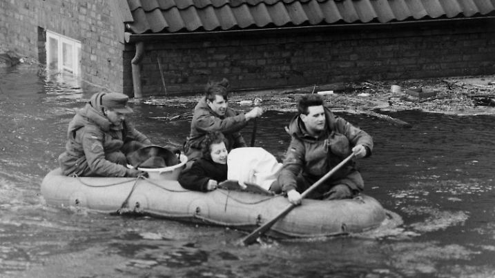 ARCHIV - 17.02.1962, Hamburg: Eine Frau wird mit einem Schlauchboot in Sicherheit gebracht. Im Hamburger Elbgebiet und im norddeutschen Küstenraum verursacht Sturmtief «Vincinette» in der Nacht zum 17. Februar 1962 die bis dahin schwerste Sturmflut des Jahrhunderts in Deutschland. (zu dpa-KORR ·Sturmflut 1962: Zeitzeugen erinnern sich an Schrecken und Abenteuer·) Foto: Gerd Herold/dpa +++ dpa-Bildfunk +++