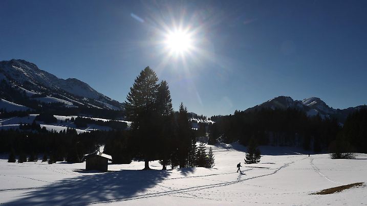 ARCHIV - 13.02.2022, Bayern, Bad Hindelang: Schneeschuhwanderer gehen im Ortsteil Unterjoch im Sonnenschein durch die winterliche Landschaft. (zu dpa «Winter in Bayern kälter als anderswo, aber mit besonders viel Sonne») Foto: Karl-Josef Hildenbrand/dpa +++ dpa-Bildfunk +++