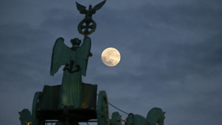 15.02.2022, Berlin: Der Vollmond geht hinter dem Adler und Ehrenkranz der Quadriga, die auf dem Brandenburger Tor steht, auf. Nach Angaben der Meteorologen werden in den kommenden Tagen die Sterne und der Mond nicht am Nachthimmel zu sehen sein, da Sturmboen mit Regenschauern und dichter Bewölkung den Blick behindern. Foto: Wolfgang Kumm/dpa +++ dpa-Bildfunk +++