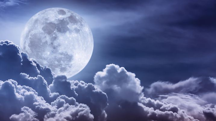 Attractive photo of background nighttime sky with clouds and bright full moon with shiny. Nightly sky with beautiful full moon behind cloud. Outdoors at night. The moon were NOT furnished by NASA.
