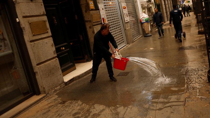 A man cleans the sidewalk, as storm Celia blew sand from the Sahara desert over Madrid, Spain, March 15, 2022. REUTERS/Susana Vera REFILE - QUALITY REPEAT