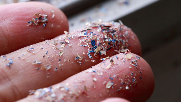Close up side shot of microplastics lay on people hand.Concept of water pollution and global warming. Climate change idea.