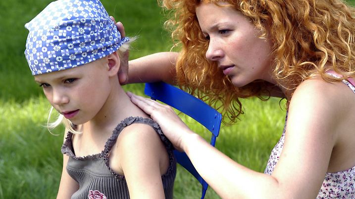 Eine Mutter sucht auf der Haut ihrer kleinen Tochter nach Zecken, aufgenommen 2005. Foto: Chiron Vaccines +++(c) dpa - Report+++