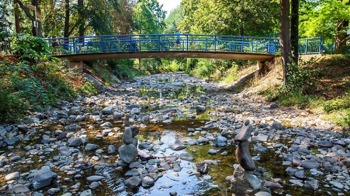 09.08.2020, Baden-Württemberg, Bad Krozingen: Der Fluss Neumagen führt auf Höhe des Kurparks in Bad Krozingen nur noch sehr wenig Wasser, während die Steine des Flussbetts bereits trocken sind. Aufgrund der hohen Temperaturen und anhaltender Trockenheit erlebt Deutschland derzeit eine historische Dürreperiode. Foto: Philipp von Ditfurth/dpa +++ dpa-Bildfunk +++