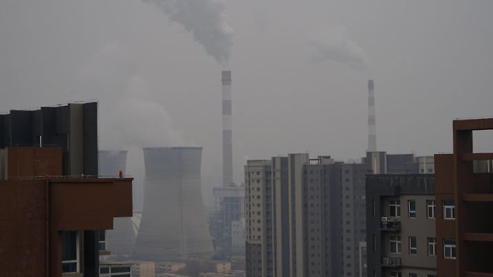 XI'AN, CHINA - DECEMBER 23, 2021 - A view of a coal-fired power plant and buildings in Xi 'an, Shaanxi Province, China, on December 23, 2021. Xi 'an has implemented city-wide closed management of units and communities.