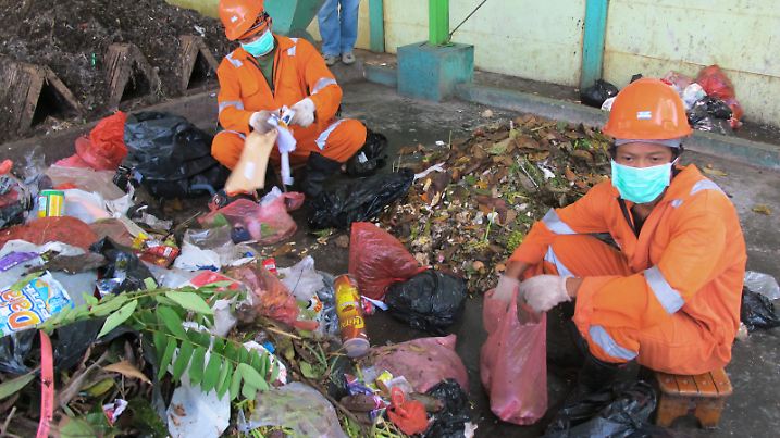Die Indonesier August und Karma (r) sortieren am 15.11.2011 Müll in Tangerang. Die Abfallentsorgung ist eine Privatinitiative der Siedlung Griya Serpong, mit Unterstützung der deutschen Hilfsorganisation Borda. Sie recyceln 70 Prozent der Abfälle, die sonst auf der Müllhalde landen und schädliche Methan-Emissionen verursachen würden. Foto: Christiane Oelrich dpa (zu dpa KORR-Ausland: "Müllentsorgung privat: Indonesier helfen Klima retten" vom 11.12.2011) ++