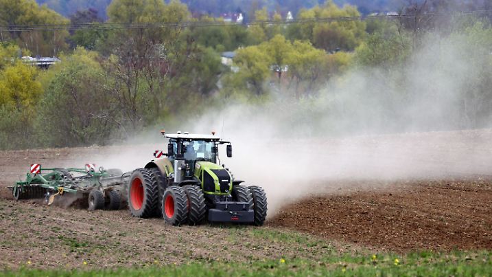 02.05.2022, Mecklenburg-Vorpommern, Clausdorf: Ein Traktor zieht beim Grubbern auf einem Feld der Papendorfer Agrargenossenschaft eine große Staubfahne hinter sich her. Der trockene Boden sorgt für eine große Staubfahne. Foto: Bernd Wüstneck/dpa +++ dpa-Bildfunk +++