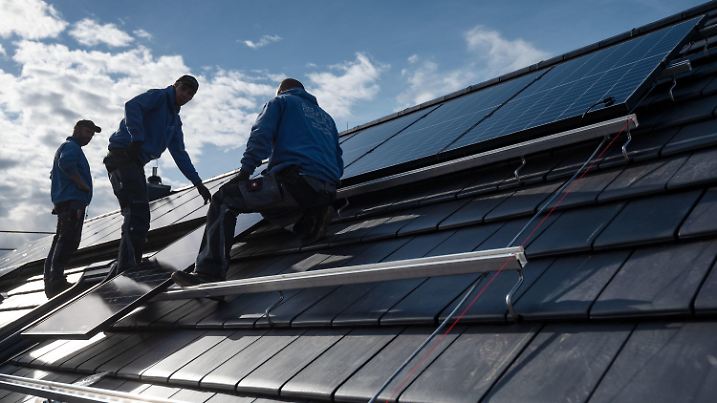 ARCHIV - 13.10.2021, Baden-Württemberg, Stuttgart: Mitarbeiter der Firma Sontec GmbH montieren Photovoltaikmodule auf dem Dach eines Wohnhauses. (zu dpa: «Solarpflicht in Baden-Württemberg bietet große Potenziale») Foto: Marijan Murat/dpa +++ dpa-Bildfunk +++
