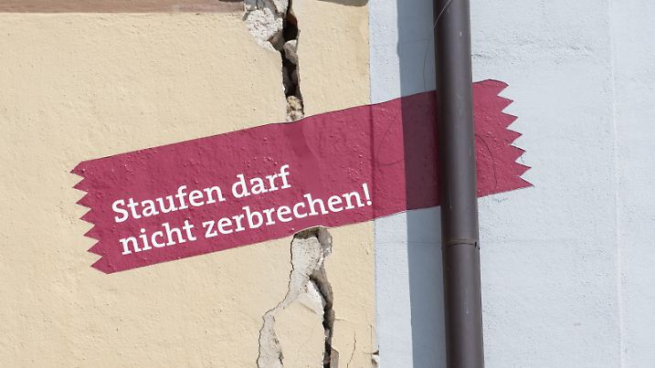 Ein aufgemaltes rotes Transparent mit der Aufschrift " Staufen darf nicht zerbrechen" hängt am 16.08.2017 in Staufen (Baden-Württemberg) am Rathaus. Vor zehn Jahren hat ein missglücktes Geothermie-Projekt für zahlreiche Risse in Gebäuden gesorgt. Die Gemeinde leidet immer noch an den Folgen. (zu dpa :"Geothermie bringt seit zehn Jahren die Kleinstadt Staufen auseinander" vom 18.08.2017) Foto: Patrick Seeger/dpa ++