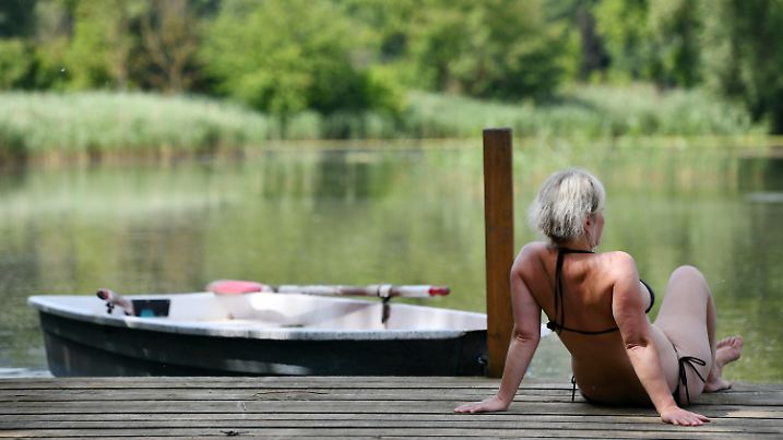 25.06.2019, Thüringen, Sondershausen: Eine Frau genießt auf einem Steg im Naturbad Bebraer Teiche die Sonne. Auch in den kommenden Tagen lädt das Wetter mit hohen Temperaturen zum Aufenthalt im Freien ein. Foto: Frank May/dpa +++ dpa-Bildfunk +++