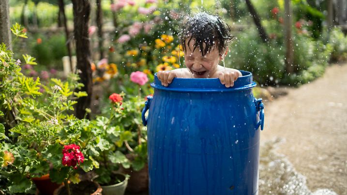Boy having fun while taking bath in the garden