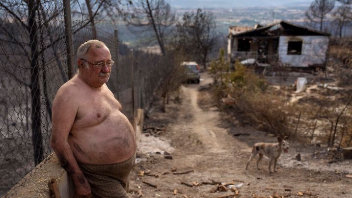 Jordi Villalta, 62, stands next to his house burnt during a wildfire in River Park village, near the town of El Pont de Vilomara, Spain, Tuesday, July 19, 2022. Jordi could not even salvage his clothes before escaping the flames, "all I have is what I'm wearing, I've lost everything" Jordi said. (AP Photo/Emilio Morenatti)