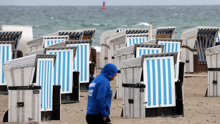 22.07.2022, Mecklenburg-Vorpommern, Warnemünde: Leere Strandkörbe stehen am Ostseestrand. Kühle Temperaturen, Regen und Wind haben die Badegäste vertrieben, der Sommer legt eine Pause ein. Foto: Bernd Wüstneck/dpa +++ dpa-Bildfunk +++