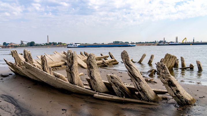 ARCHIV - 20.07.2022, Nordrhein-Westfalen, Kleve: Durch das Niedrigwasser wird auf dem Rhein bei Kleve ein Wrack freigelegt. Die Trockenheit schränkt das Geschäft der Frachtschiffe auf dem Rhein und anderen Flüssen in Deutschland stark ein. (zu dpa «Fluss-Pegel sinken immer weiter - Schifffahrt beklagt Fehlplanung») Foto: Arnulf Stoffel/dpa +++ dpa-Bildfunk +++
