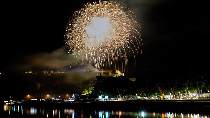 11.08.2018, Rheinland-Pfalz, Koblenz: Das Abschlussfeuerwerk des Feuerwerk-Spektakels "Rhein in Flammen" wird von der Festung Ehrenbreitstein aus abgeschossen. Im Vordergrund sind die Moselmündung und das Deutsche Eck mit dem Reiterstandbild von Kaiser Wilhelm zu sehen. Foto: Thomas Frey/dpa