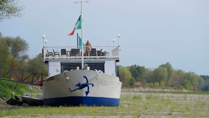 28.07.2022, Italien, Ficarolo: Ein Bootsrestaurant liegt auf dem ausgetrockneten Flussbett an einem Touristenanleger am Po. Die Dürre hat die für die Bewässerung wichtigen Flüsse ausgetrocknet und bedroht nach Angaben der italienischen Agrarlobby Coldiretti die Landwirtschaft mit rund 3 Milliarden Euro. Foto: Luca Bruno/AP/dpa +++ dpa-Bildfunk +++