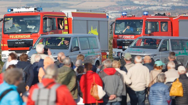 03.09.2022, Sachsen-Anhalt, Schierke: Fahrgäste der Harzer Schmalspurbahn HSB stehen am 03.09.22 am Bahnhof Brocken und warten auf die Evakuierung mit Fahrzeugen. Unterhalb des Gipfels des Berges war ein Waldbrand ausgebrochen. Foto: Matthias Bein/dpa +++ dpa-Bildfunk +++