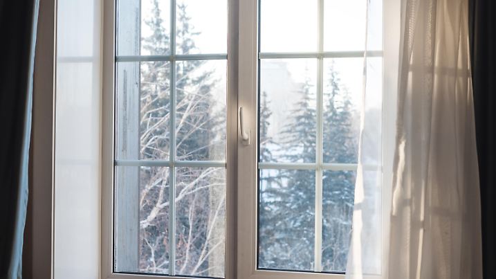 White window frame with curtain blowing by wind, winter scenic view in the morning